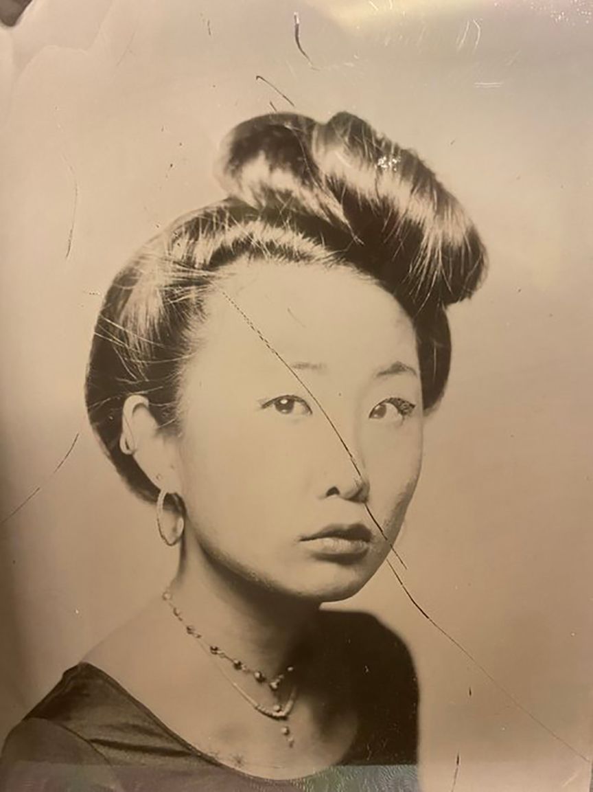 A black and white photo of a woman with a bun in her hair.