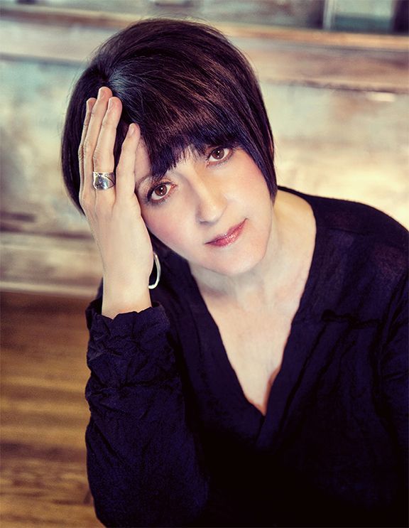 The woman is wearing a black shirt and a ring on her finger.