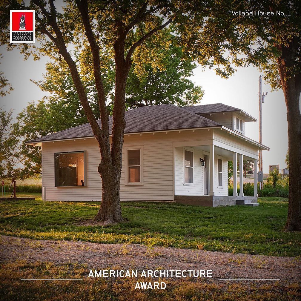 White house with porch, trees in the yard. American Architecture Award logo in corner.