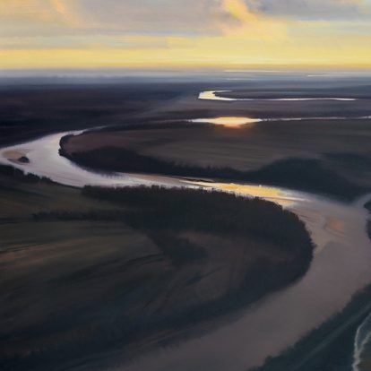 A river winds through a dark landscape, reflecting the sunset's golden light.