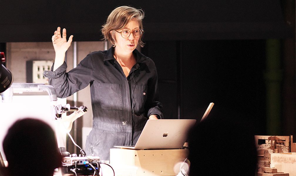 A woman is standing in front of a laptop computer.
