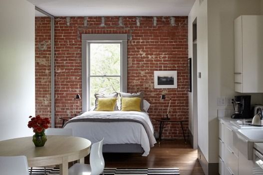 A bedroom with a brick wall and a bed