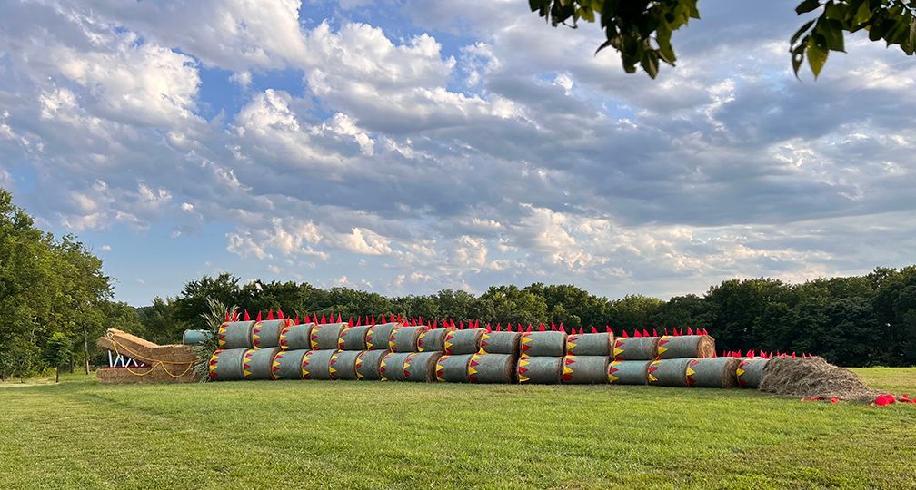 A large snake made out of hay bales in a field.
