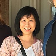 A woman is smiling for the camera while standing next to another woman.