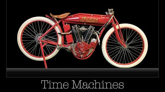 A red motorcycle with white tires and the words time machines below it