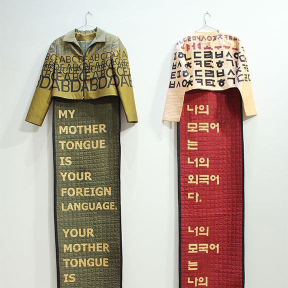 Two textile artworks: Jackets with long panels. One reads
