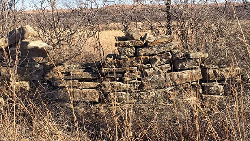 A pile of rocks is sitting in the middle of a field.