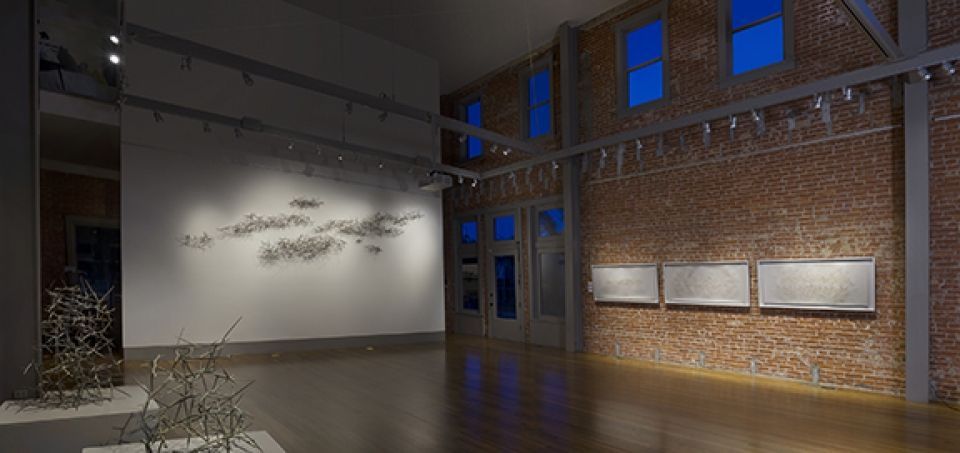 A large empty room with a brick wall and a wooden floor.