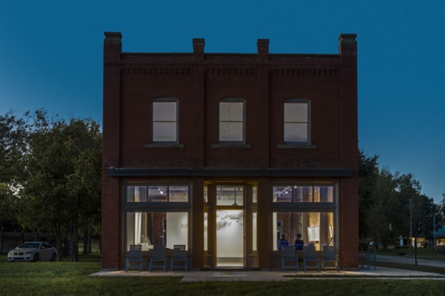 A brick building with a lot of windows is lit up at night.