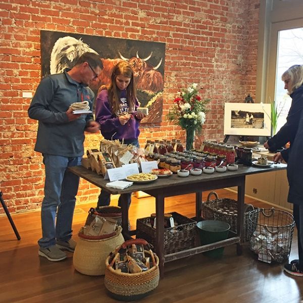 A group of people standing around a table with food on it