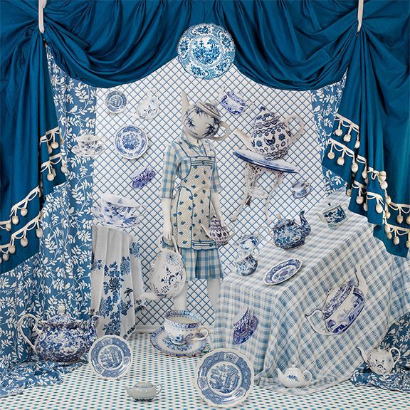 A display of blue and white plates and a mannequin