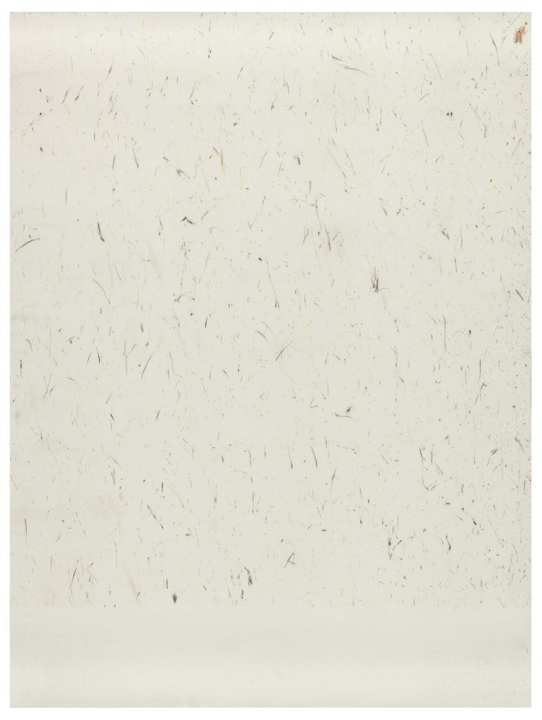 A close up of a white tile with spots on it.