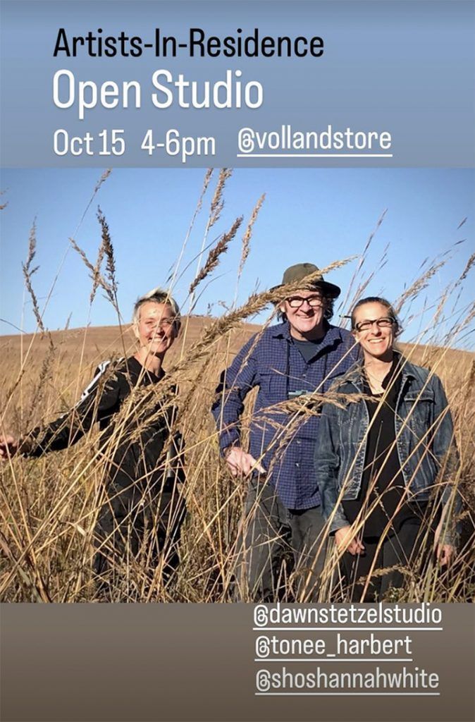 A group of people are standing in a field of tall grass.