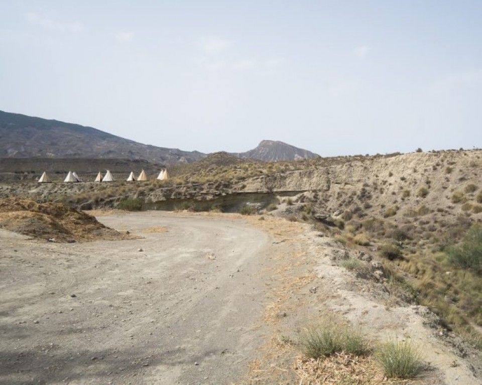 A dirt road in the desert with mountains in the background