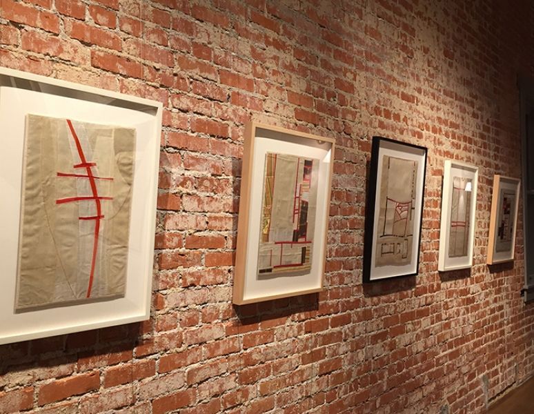 A brick wall with a row of framed pictures on it