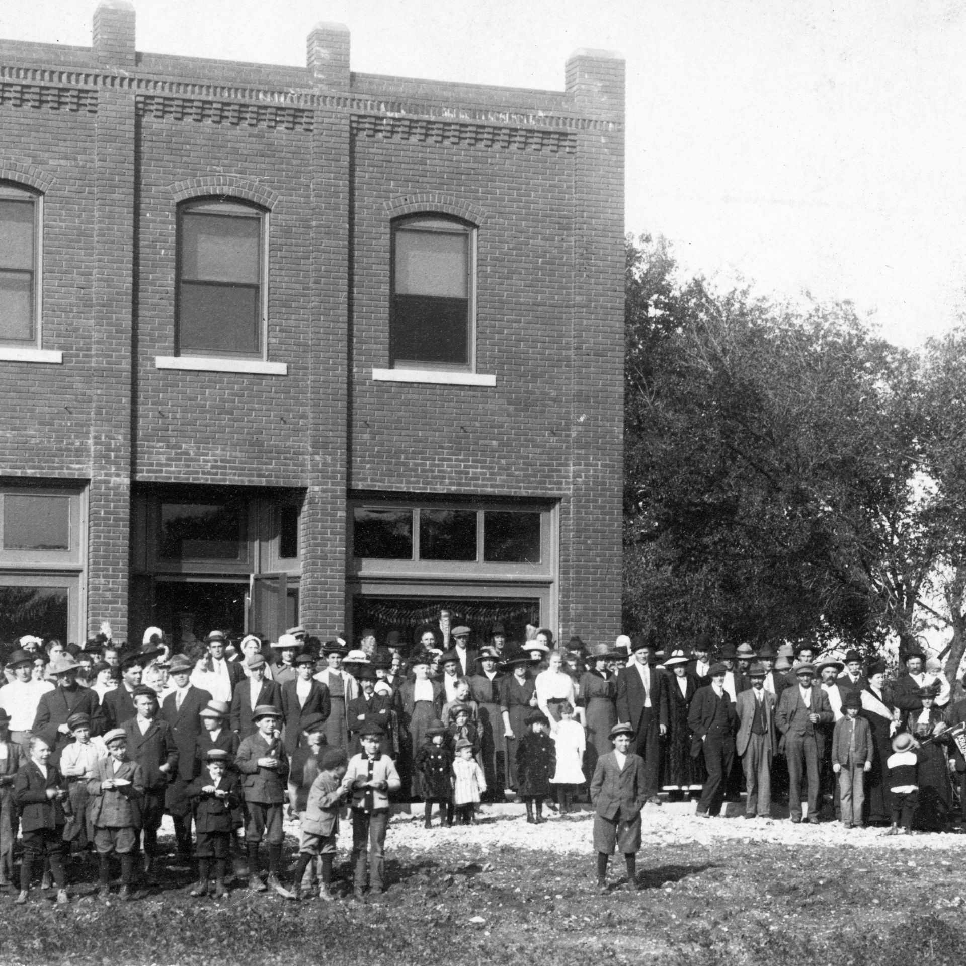 A group of people standing in front of a brick building