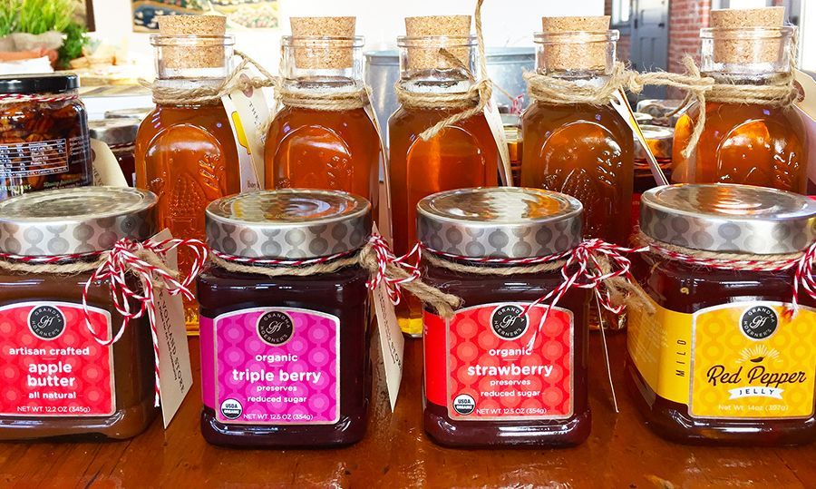 Jars of honey and preserves on display, with wooden corks and colorful labels.