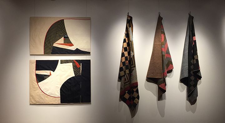 Four paintings are hanging on a wall next to each other.