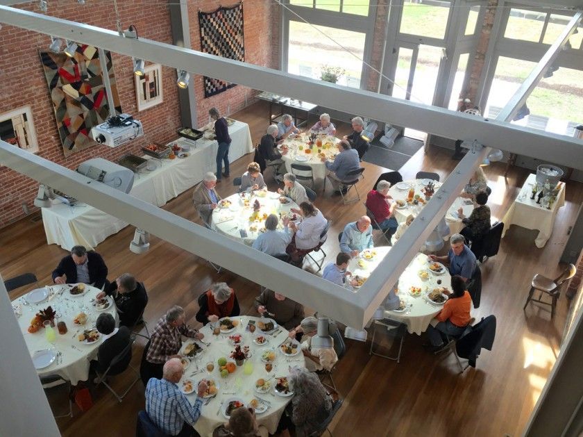 A group of people are sitting at tables in a large room.