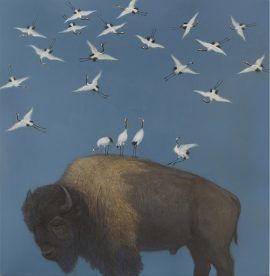 Buffalo with cranes perched on its back, flock of cranes flying in a blue sky.