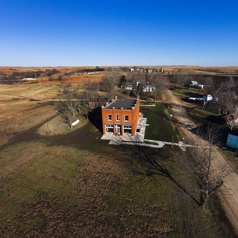 An aerial view of a large brick building in the middle of a field.