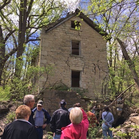 A group of people are standing in front of an old building