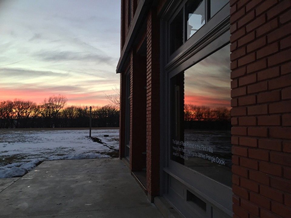 A brick building with a sunset in the background