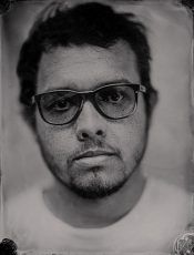 A black and white photo of a man wearing glasses and a beard.