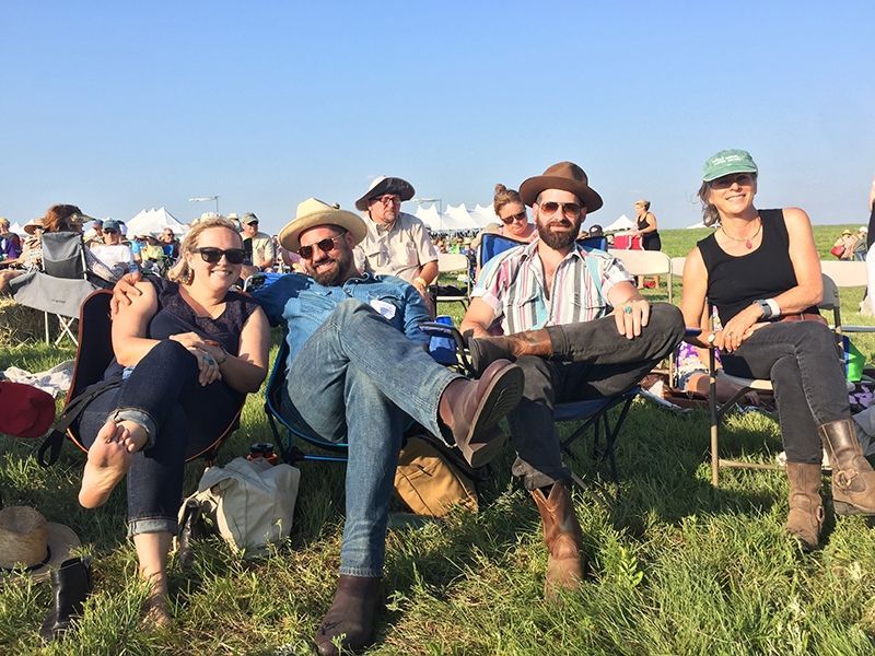 A group of people are sitting in chairs in the grass.