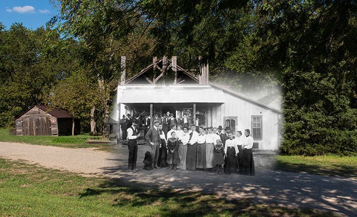 A group of people are standing in front of a white house.