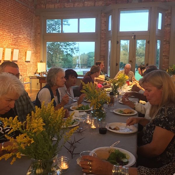 A group of people are sitting at a long table eating food.