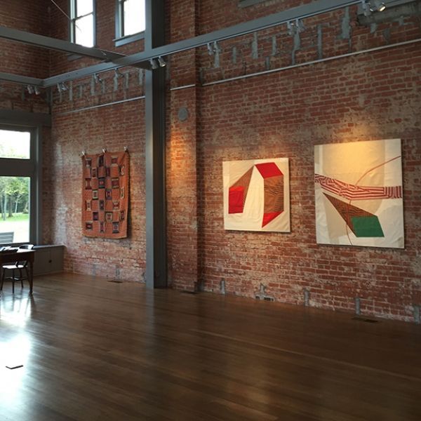 A room with a brick wall and paintings on it