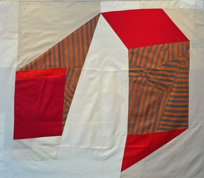 A red and white quilt with a striped pattern