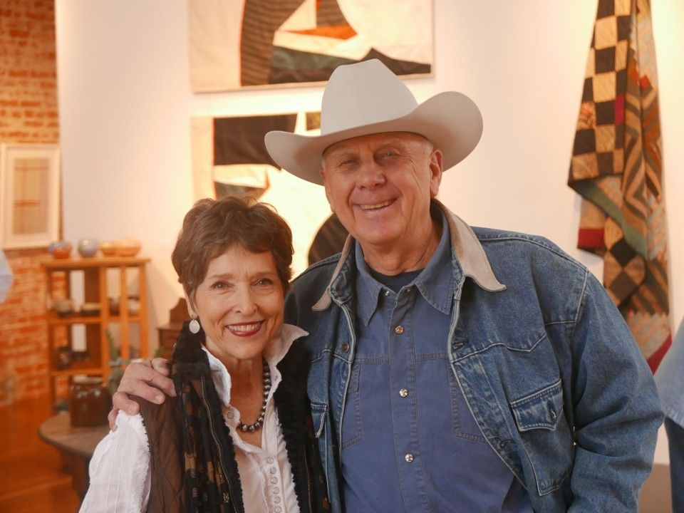 A man in a cowboy hat is posing for a picture with a woman