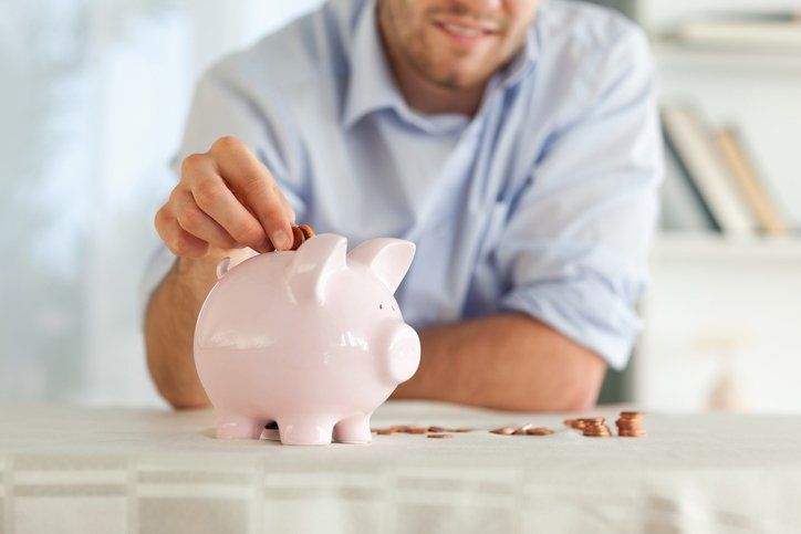 Cash Lending Service — Man Pouring Coins in Piggy Bank in San Antonio, TX