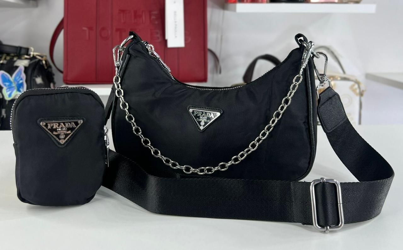 Conjunto de bolso Prada negro con bolsito, cadena plateada y logotipo.