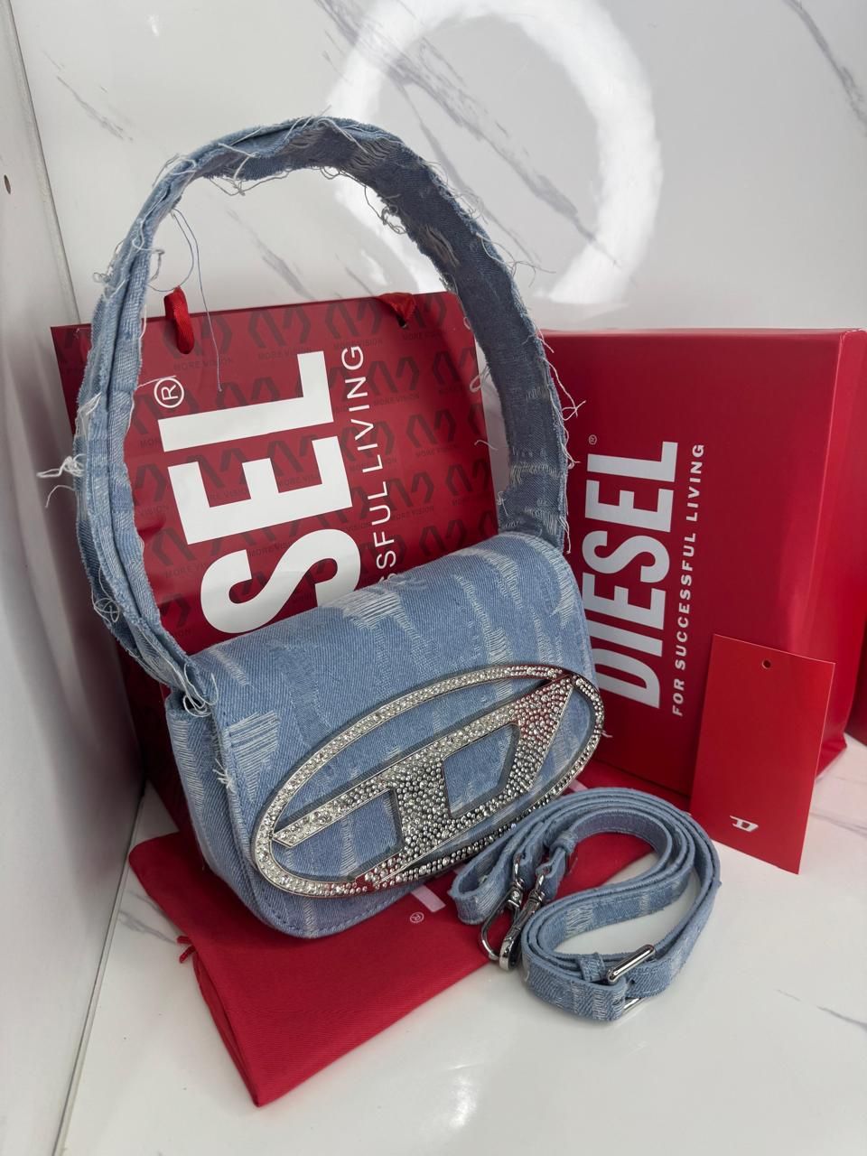 Bolso de mano Diesel en denim con logotipo joya, bolso de compras Diesel en color rojo y caja roja.
