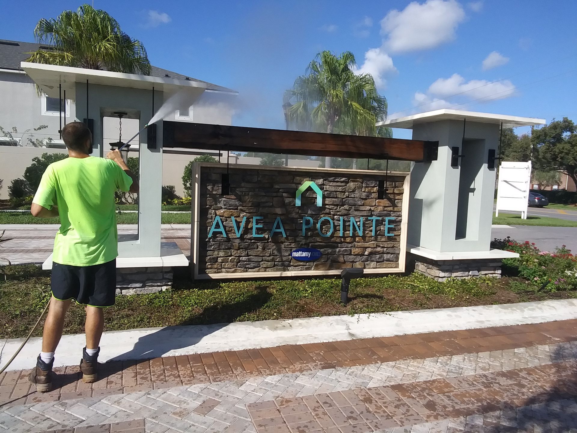 Man in green shirt power washing 