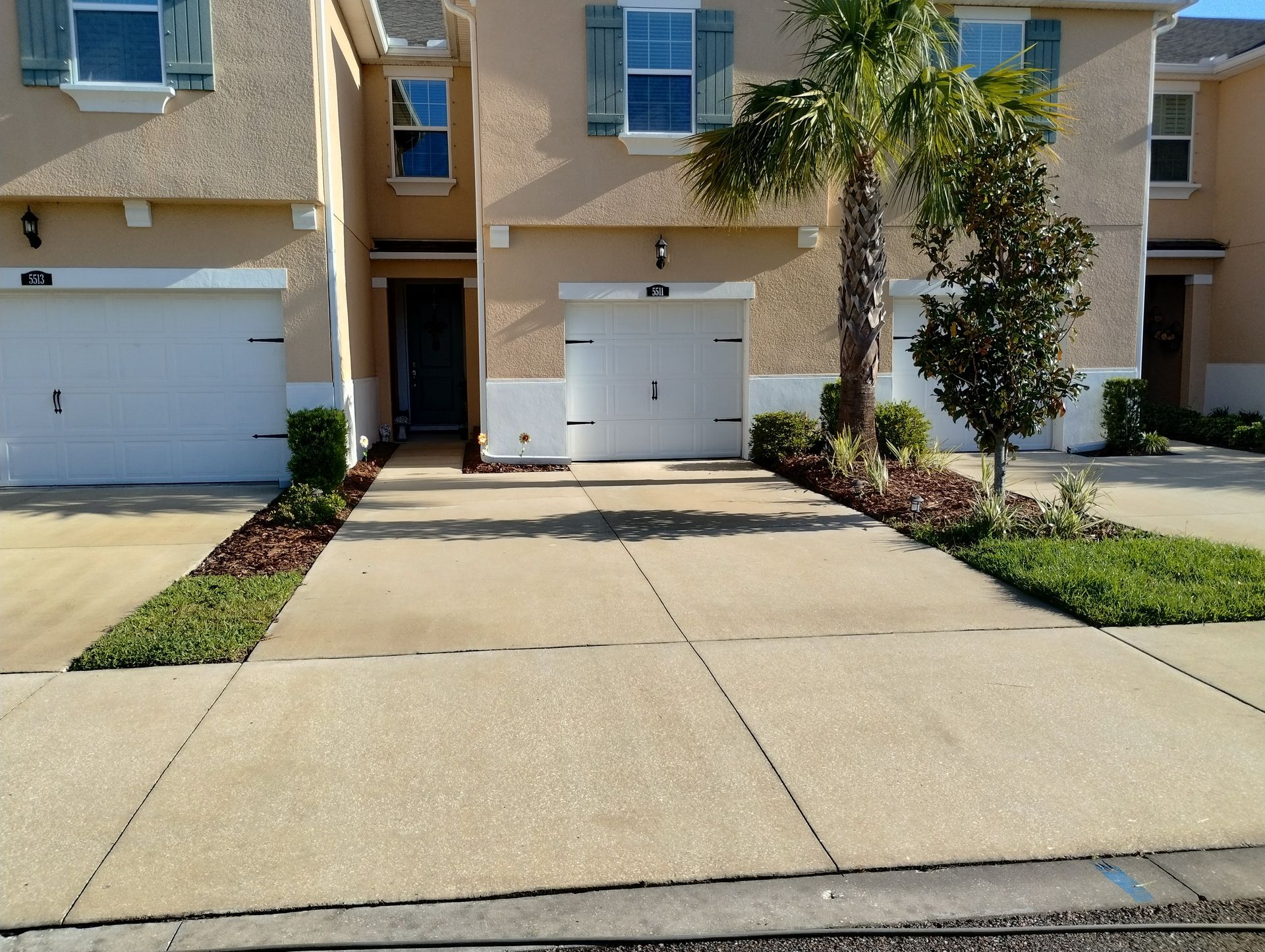 Townhouse exteriors with garages, driveways, and landscaping.