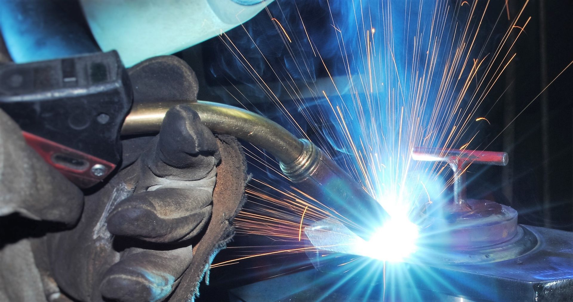 A close up of a person welding a piece of metal