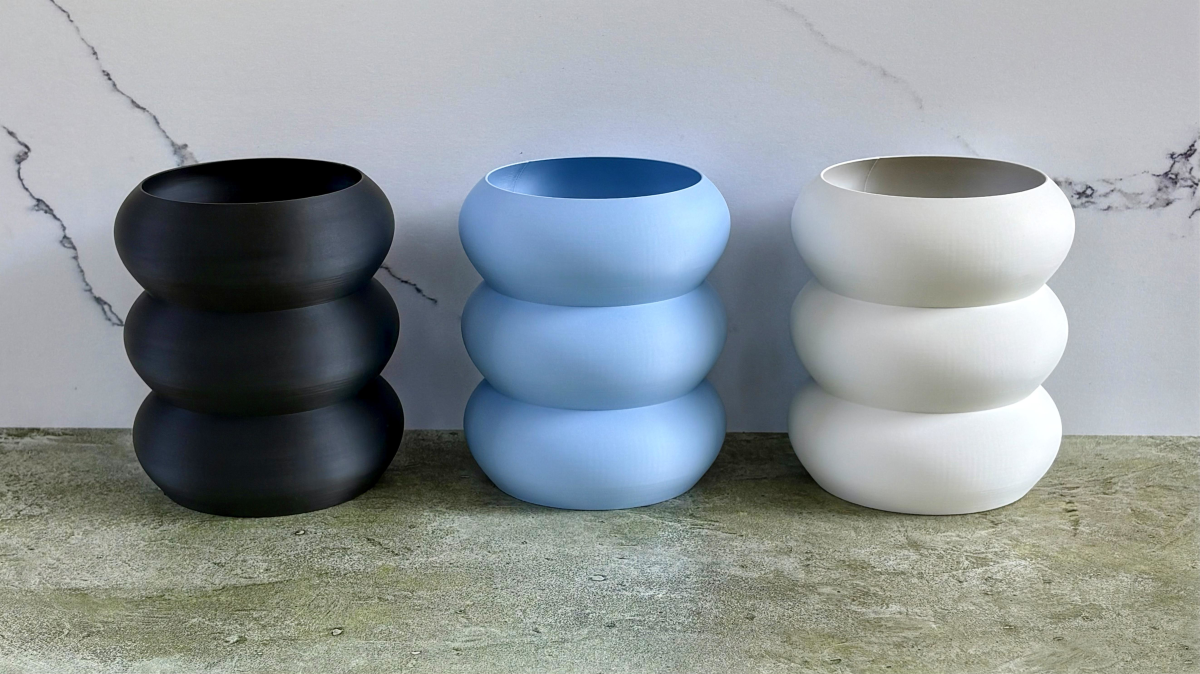 Three stacked bubble vases in black, light blue, and white.