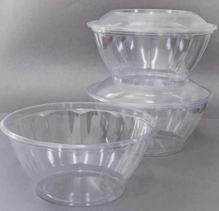 Tres cuencos de plástico transparente con sus tapas a juego, apilados sobre un fondo gris.