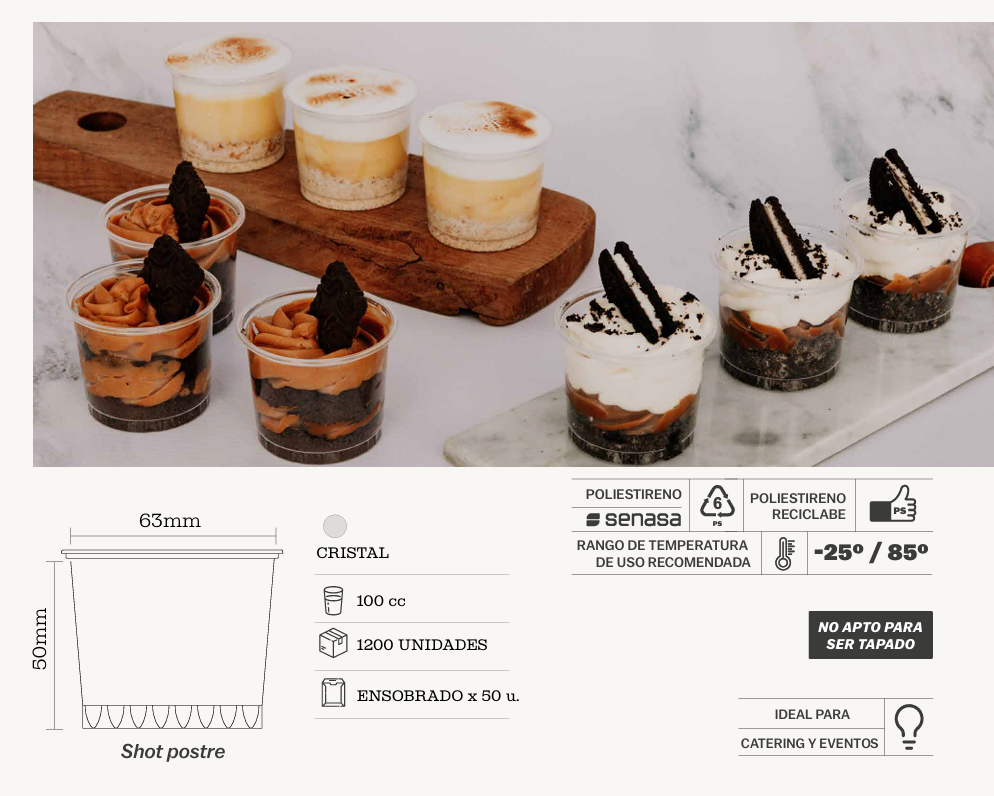 Una mano sostiene un pequeño vaso de plástico lleno de capas de galletas de chocolate trituradas.