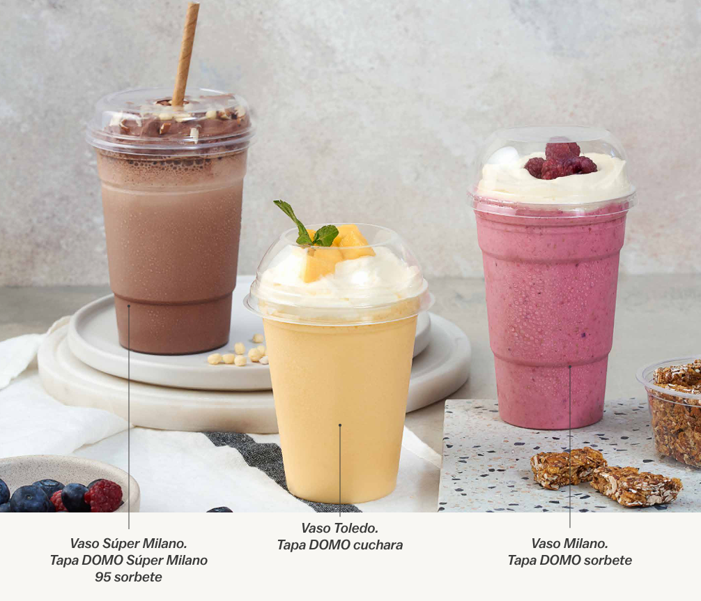 Tres vasos de plástico con diferentes batidos, cada uno con una tapa transparente en forma de cúpula