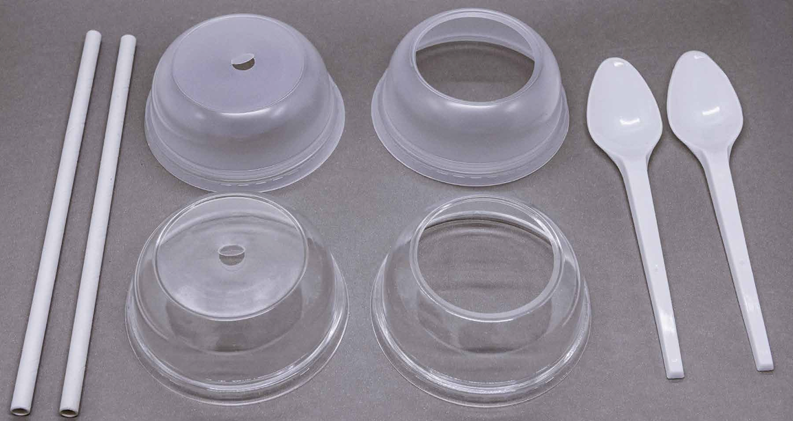 Dos pajitas blancas, dos tapas de plástico con forma de cúpula y orificio central, dos tapas