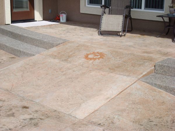 A concrete patio with a chair and stairs