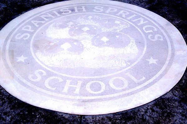 Spanish springs school is written on a white circle
