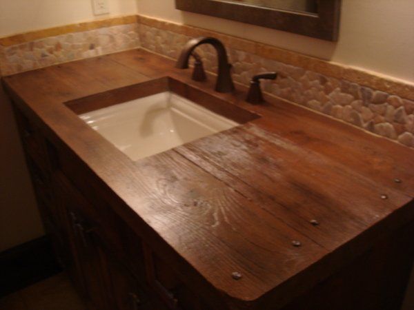 A bathroom sink with a wooden counter top