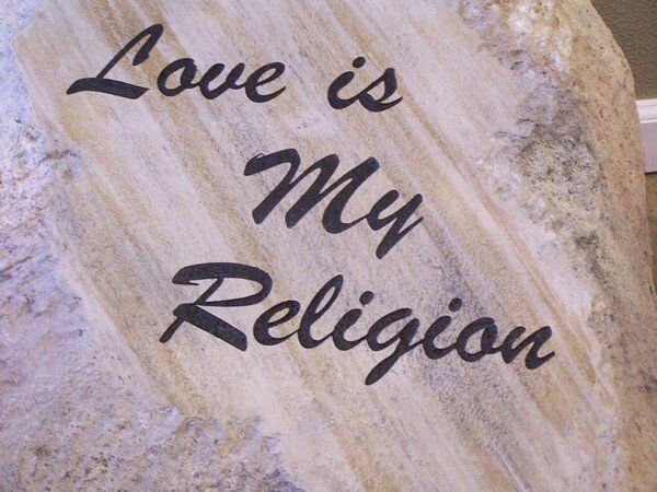 A wooden sign that says love is my religion