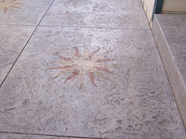 A concrete floor with a sun design on it